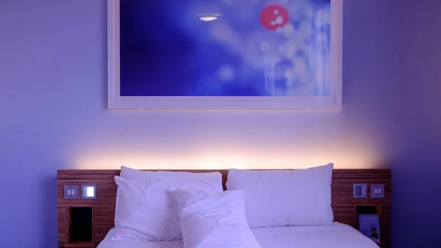 Close-up of high-quality white cotton sheets showing fabric texture and weave detail on a bed