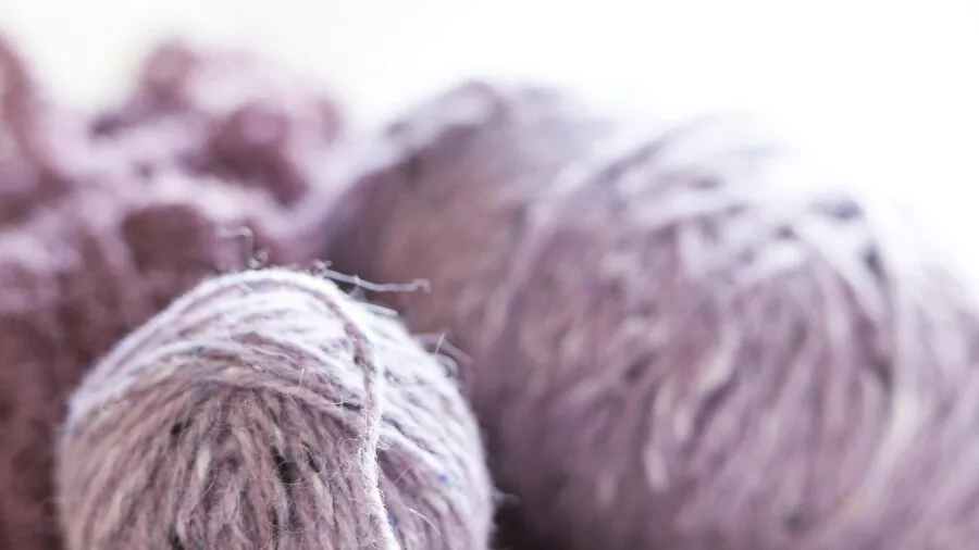 Close-up of knitted cable stitch pattern in solid color yarn showing detailed texture definition