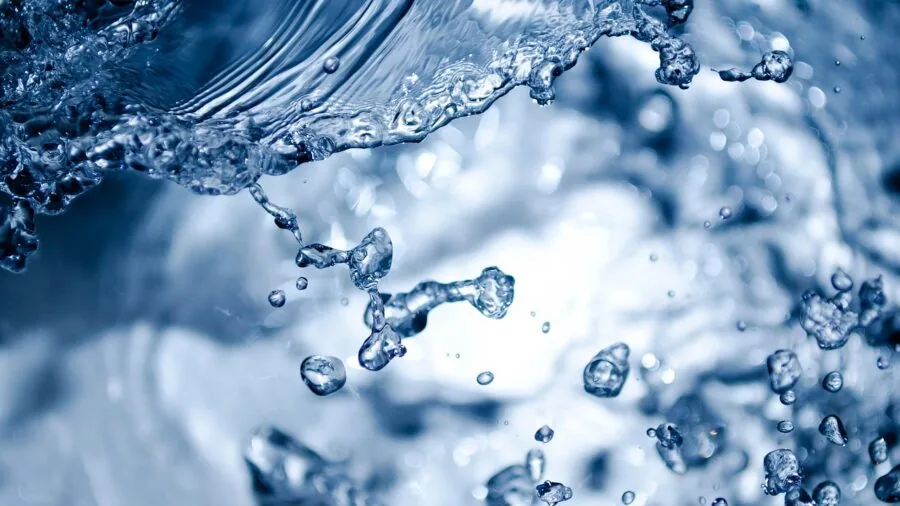 Close-up of liquid being poured through a fine mesh strainer into a bowl during food preparation