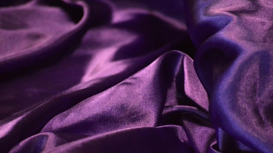 Close-up of luxurious satin fabric with natural light creating elegant highlights and soft drapes