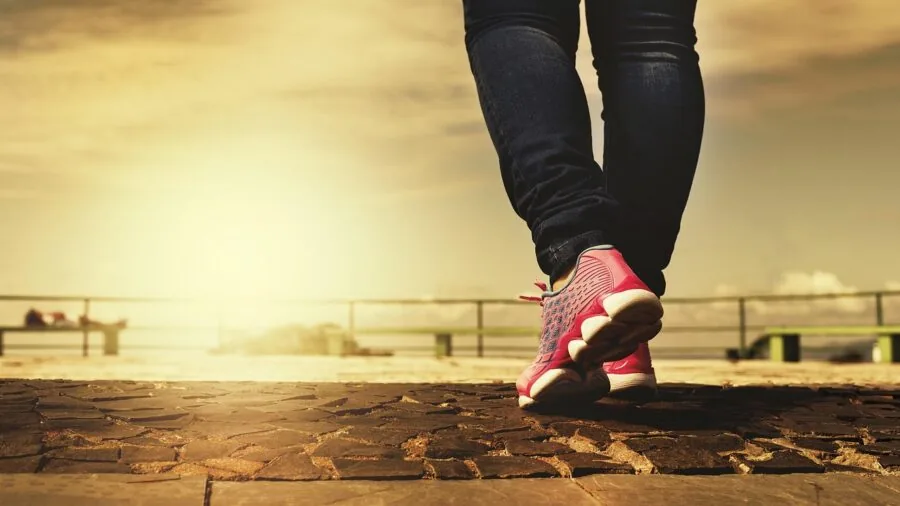 Close-up of male runner's feet making contact with pavement during outdoor running session