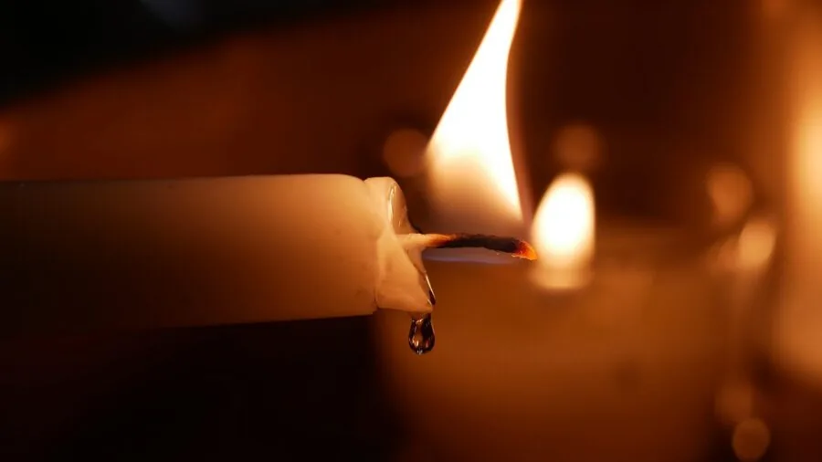 Close-up of melted wax being poured into a candle container during the candle making process