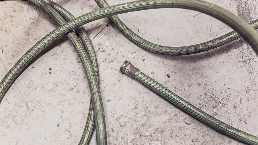 Close-up of metal garden hose coupling connector during outdoor watering task
