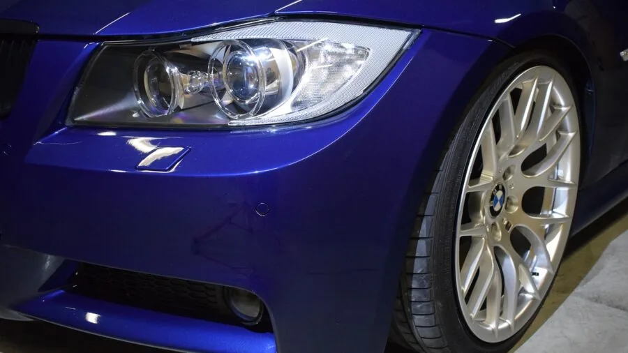 Close-up of orbital polisher in motion on car paint surface during professional detailing work