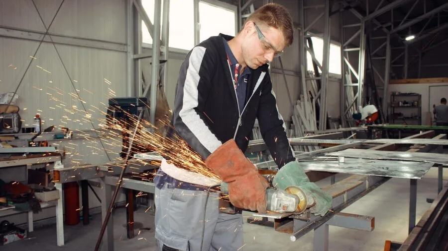 Close-up of person inspecting safety goggle lens for scratches and durability in natural light
