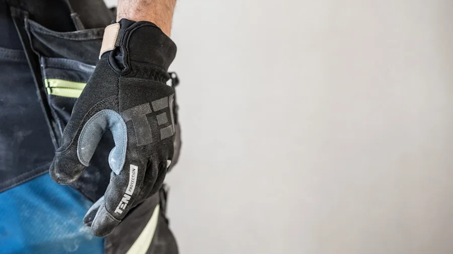 Close-up of person securing work glove wrist closure during job site preparation