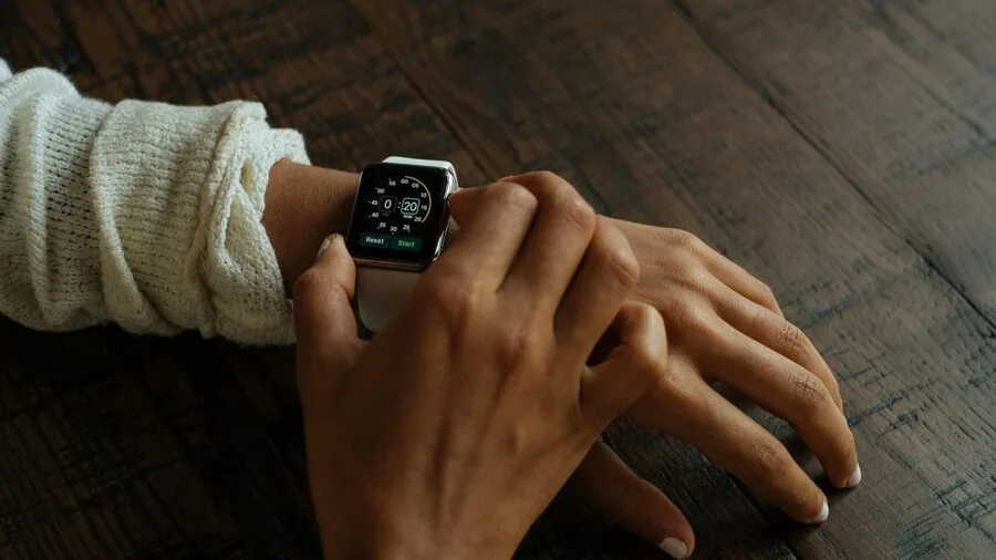 Close-up of person wearing wrist device while sleeping peacefully in bed at night