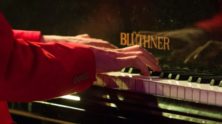 Close-up of pianist's hands demonstrating finger technique and touch sensitivity while playing piano keys