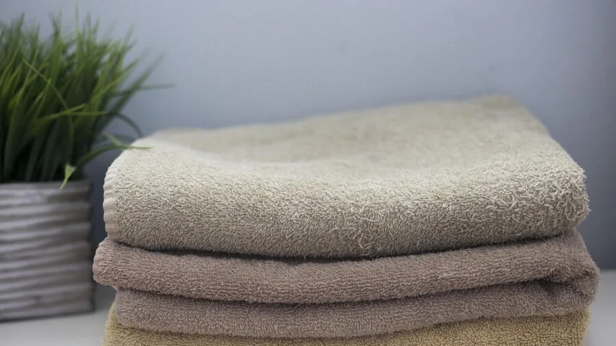 Close-up of plush folded cotton towels in natural light showing texture and quality fibers