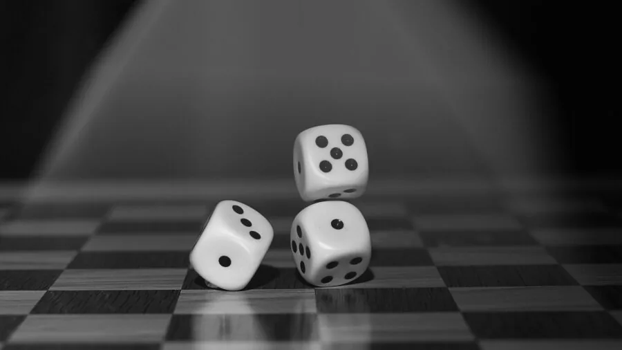 Close-up of polyhedral dice rolling across a wooden gaming table during a tabletop RPG session