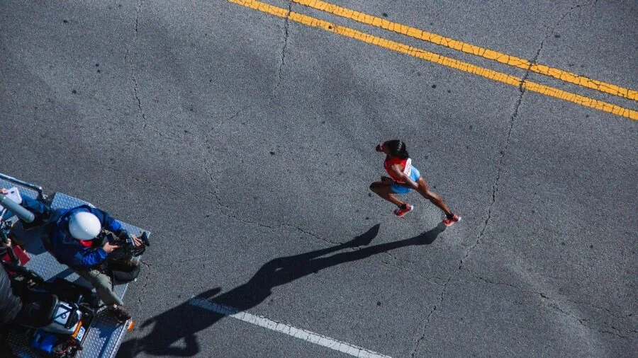 Close-up of runner's feet hitting pavement during road run, showing shoe cushioning in action