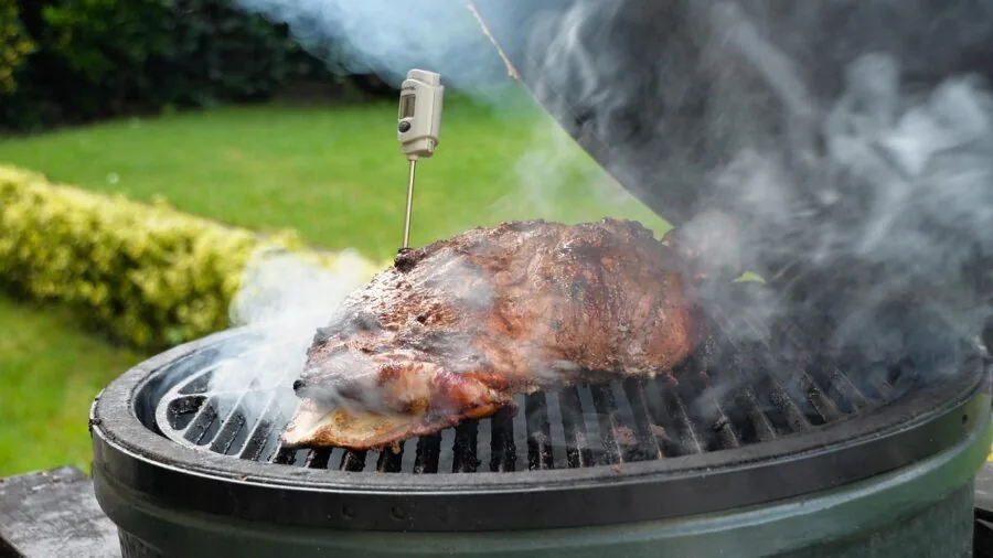 Close-up of sizzling steak being seared over high heat flames on outdoor grill