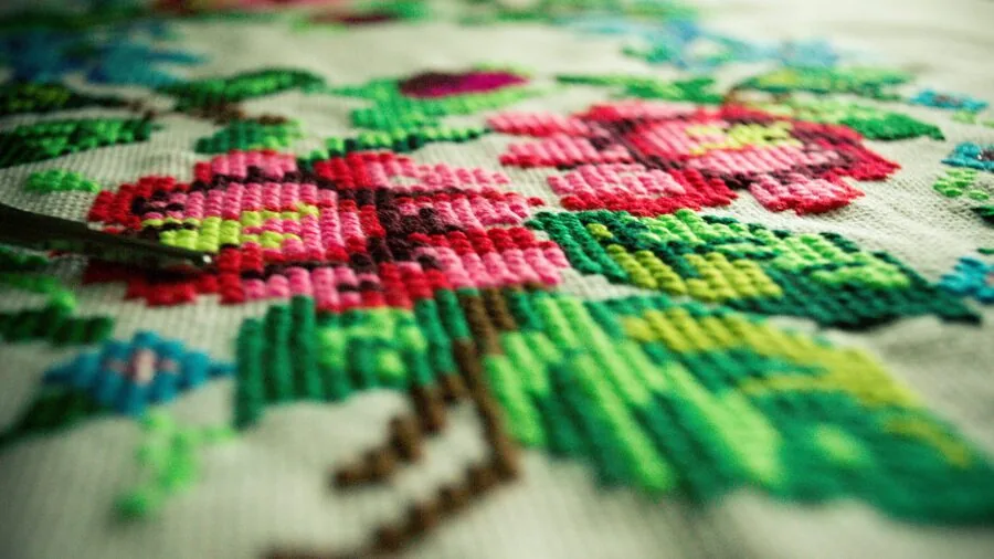 Close-up of skilled hands examining detailed stitching and seams on leather material during craftsmanship work