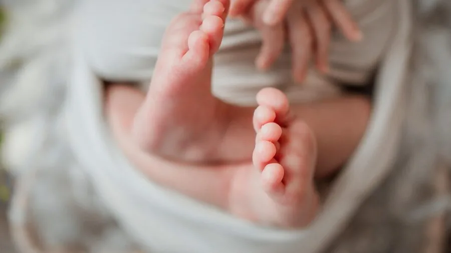 Close-up of soft fabric material touching a baby's foot, showing texture and comfort