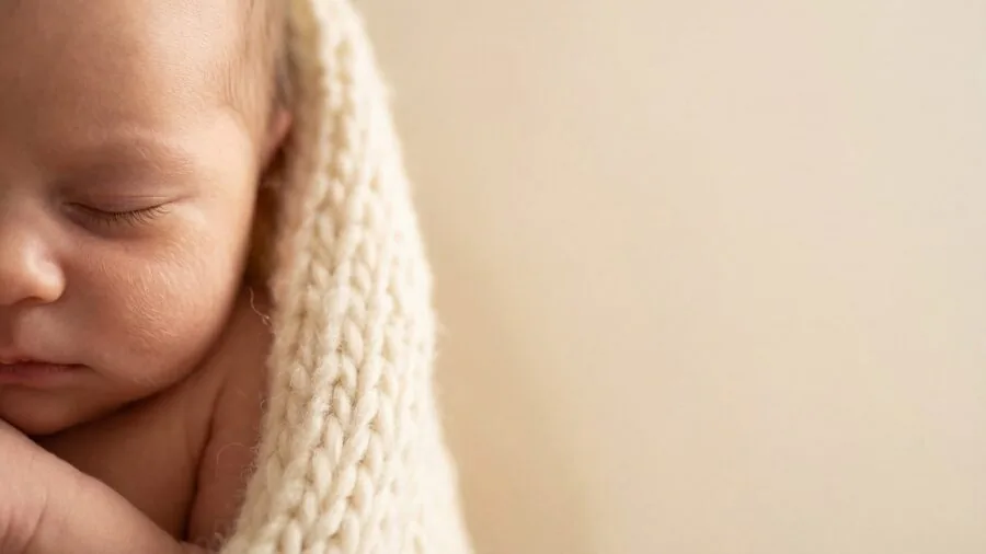 Close-up of soft, gentle fabric texture touching delicate newborn skin in natural lighting