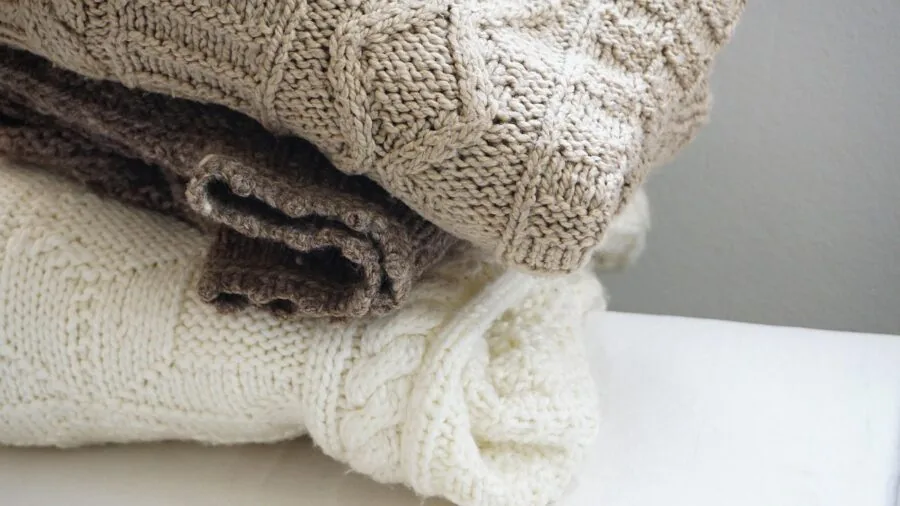 Close-up of soft knit fabric being touched, showing comfortable textile quality and weave detail