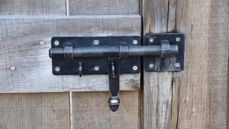 Close-up of someone inspecting a residential door lock mechanism and hardware durability