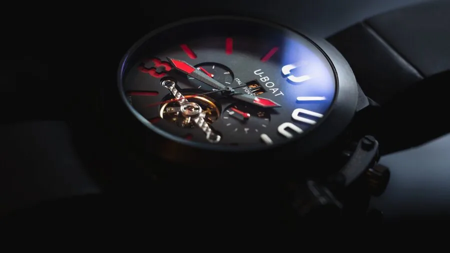 Close-up of someone inspecting an automatic watch movement and internal mechanisms