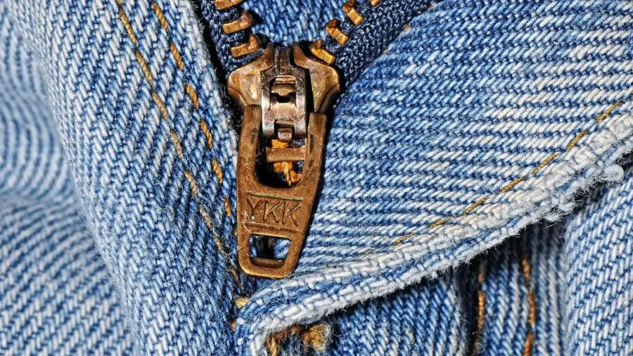 Close-up of someone inspecting clothing seams and stitching quality in natural daylight