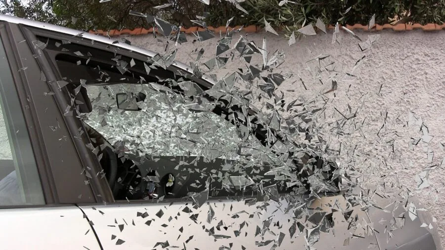 Close-up of tempered glass breaking into small granules after impact force application