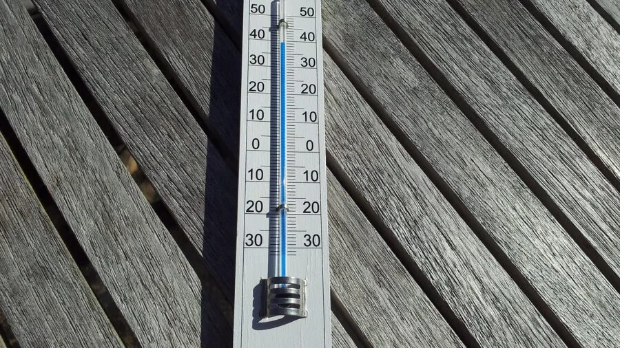 Close-up of thermometer showing cold temperature during winter RV camping trip in snowy landscape