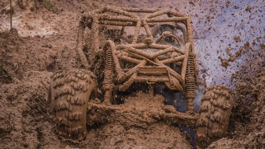 Close-up of trail runner's shoe gripping muddy terrain during outdoor run