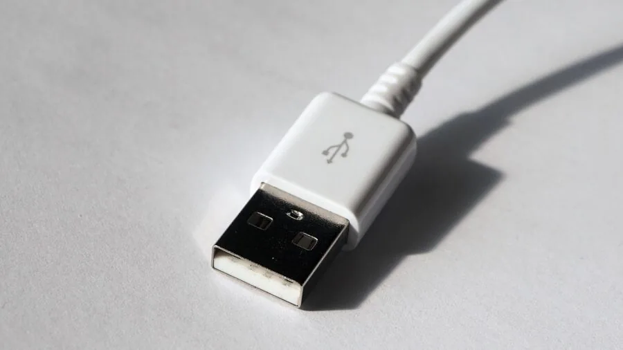 Close-up of USB cables and ports connected to electronic devices on a desk workspace