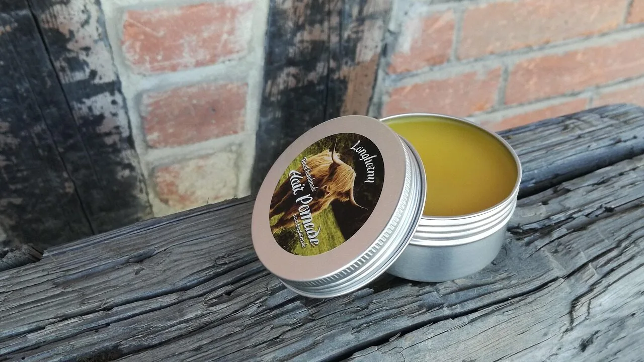 Close-up of various hair pomade containers arranged together showing different styles and finishes