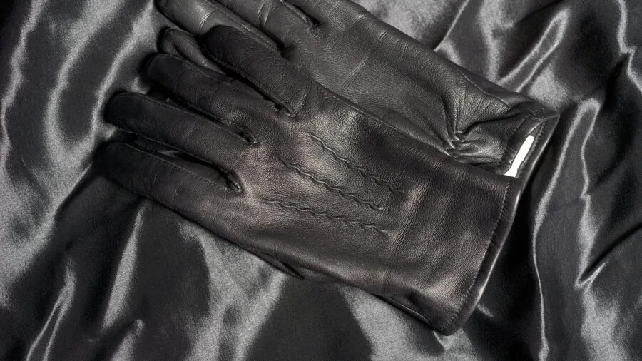 Close-up of various leather glove textures and types displayed on hands in natural daylight