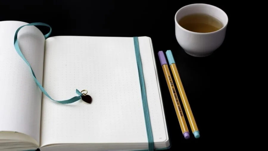 Close-up of vibrant markers and highlighters being used on planner pages with various colors