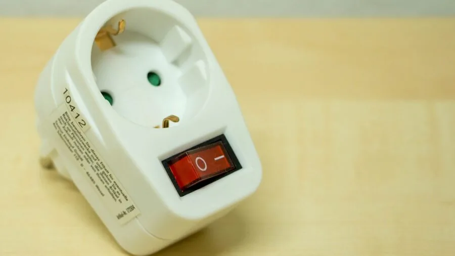 Close-up of wall outlet with charging cable during daytime indoor setting
