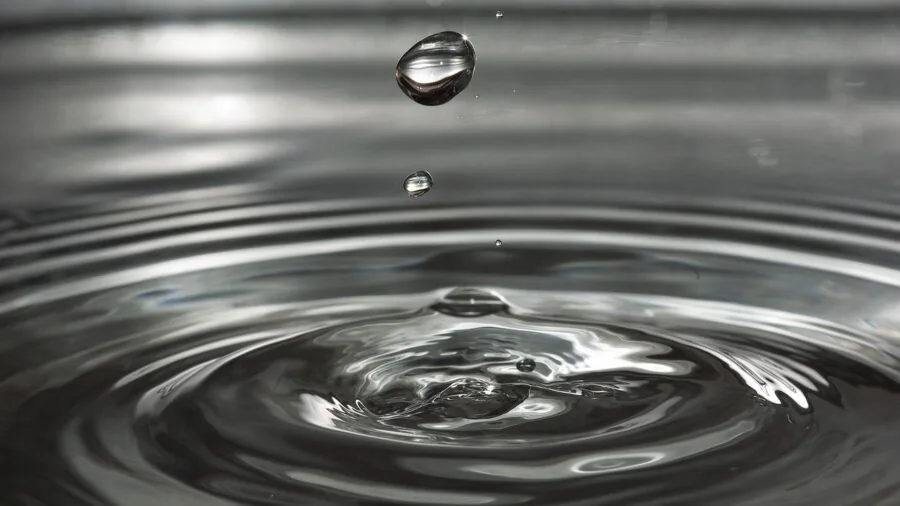 Close-up of water droplets being absorbed into fabric fibers, demonstrating liquid absorption and capillary action