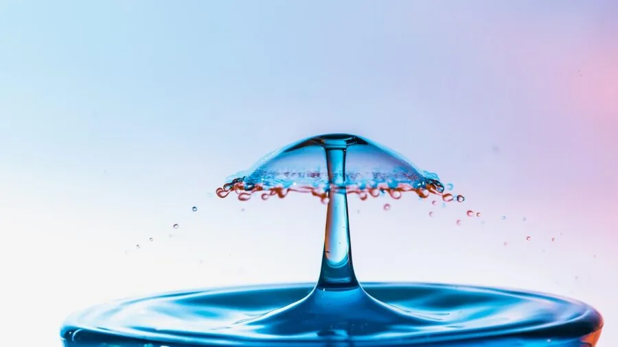 Close-up of water droplets splashing on a wristwatch during durability testing in natural light