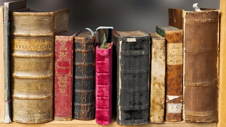Close-up of weathered leather bookmark with natural patina showing texture and wear from regular use in open book