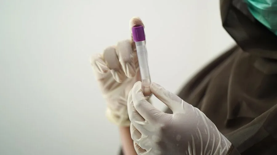 Close-up of worker wearing protective gloves with extended cuff coverage on forearms during safety work