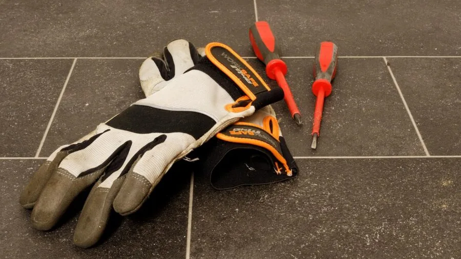 Close-up of worker's hands wearing protective gloves during manual work task