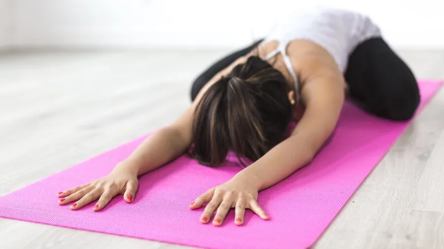 Close-up of worn yoga mat surface showing compression marks from regular use and practice