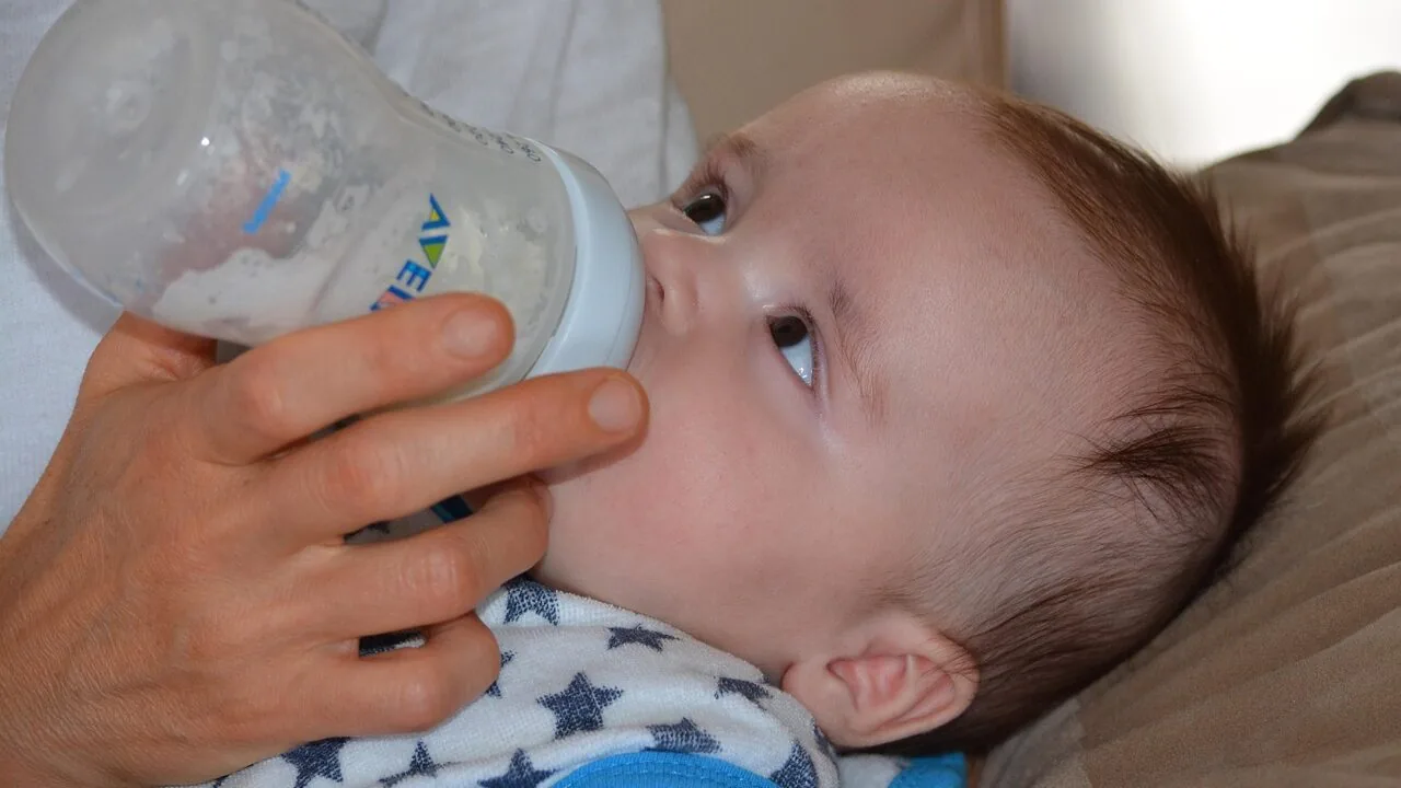 Collection of baby bottles with formula or breast milk in various sizes and styles