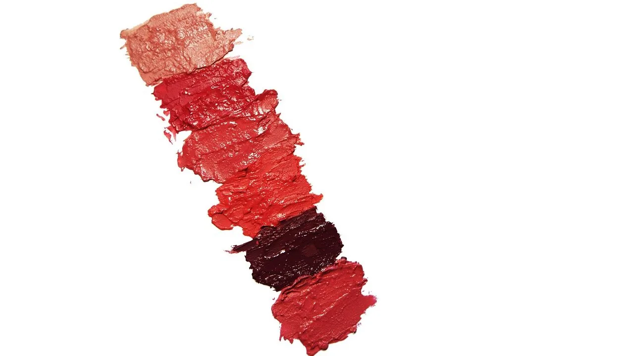 Collection of colorful lip gloss bottles displayed with swatches showing glossy finishes