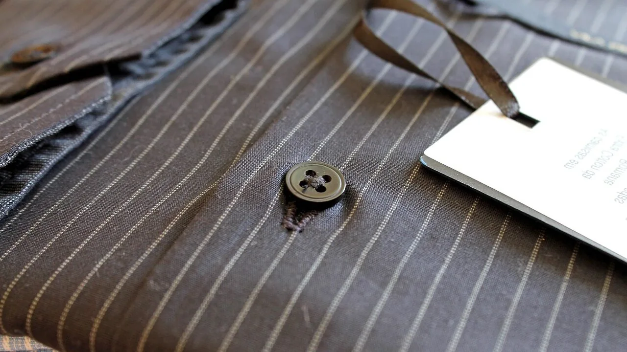 Collection of folded and hanging men's dress shirts in various colors and patterns