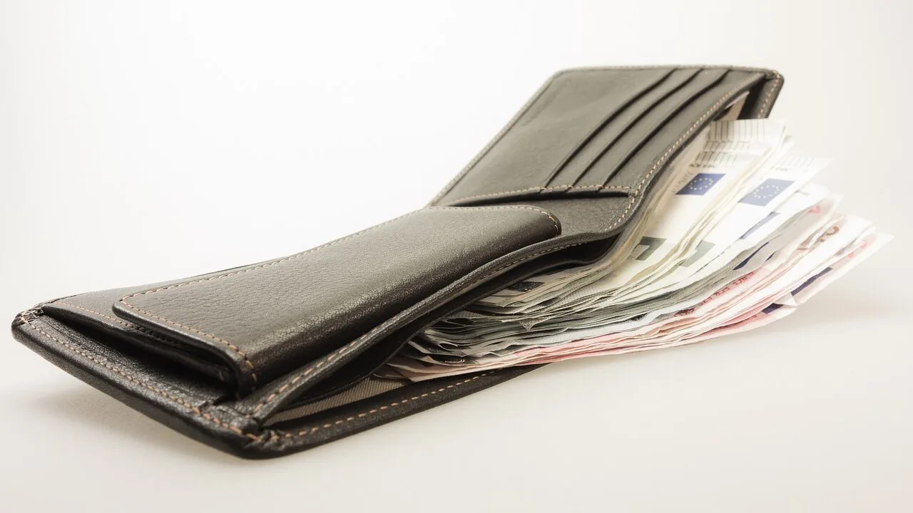 Collection of men's leather wallets in various colors and styles arranged on white background