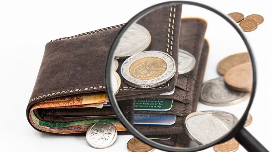 Collector closely inspecting coin details with magnification tool for authentication and grading