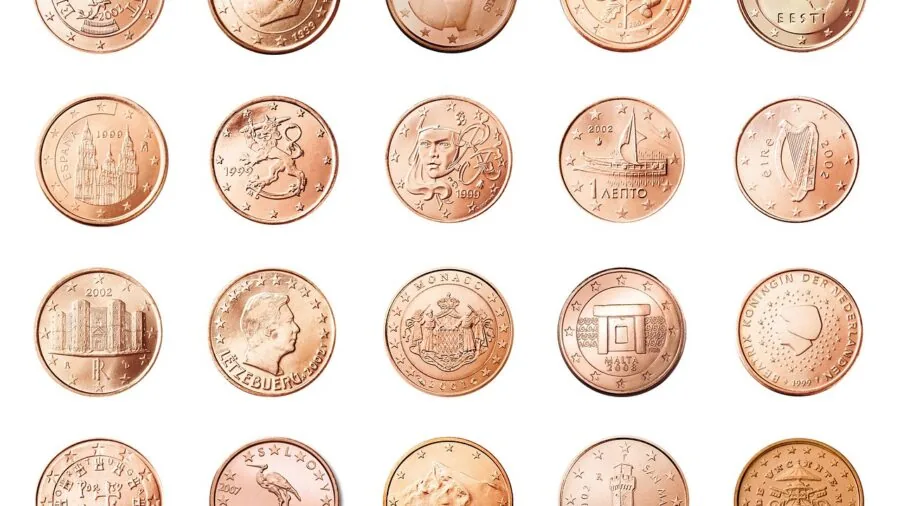 Collector organizing and sorting coins by type and denomination at a wooden desk