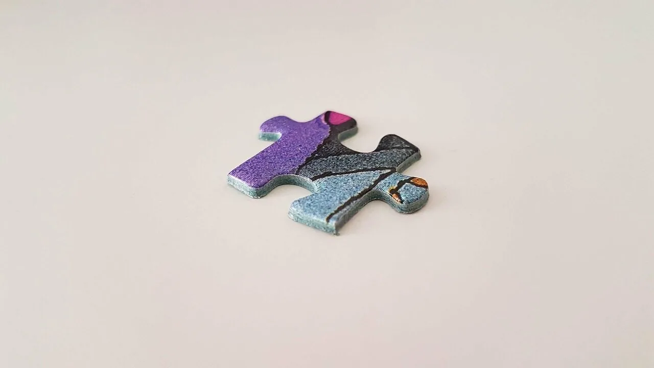 Colorful jigsaw puzzle with pieces scattered on wooden table during assembly