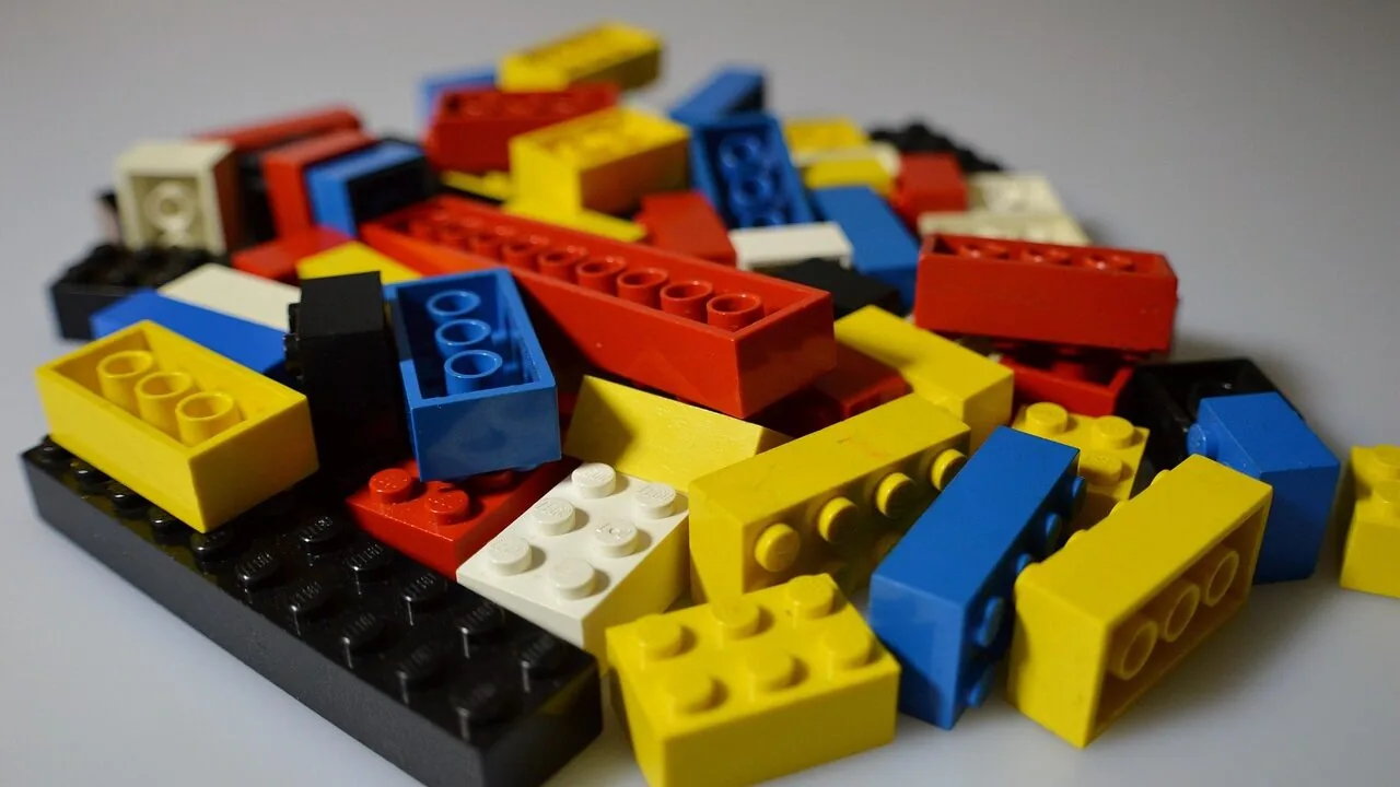 Colorful STEM toys including building blocks, gears, and educational construction sets arranged on white background
