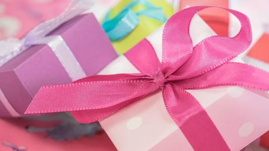 Colorful wrapped gift box with ribbon on wooden surface, ready for giving