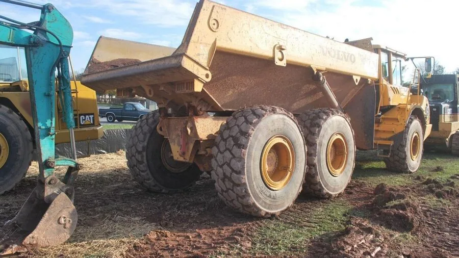 Construction professional loading industrial equipment into work van at job site