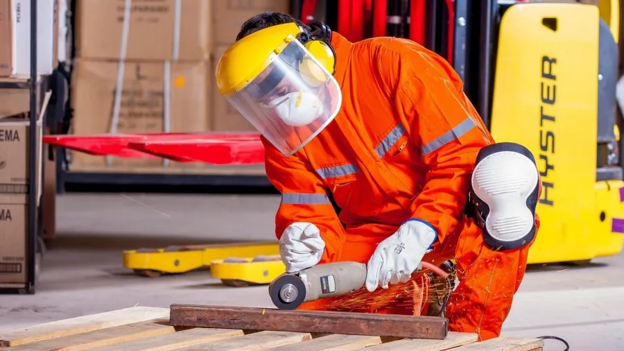 Construction worker examining work boot material and safety features on job site