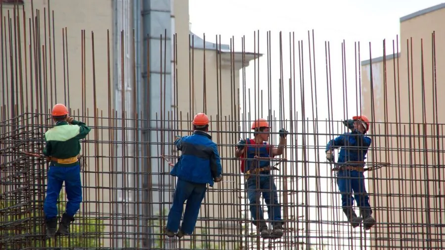 Construction worker kneeling on concrete surface during job site work