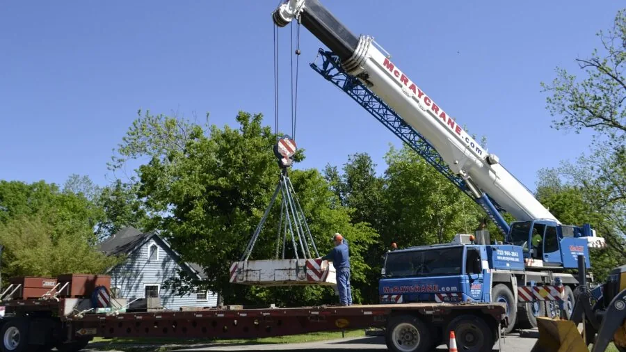 Construction worker using lifting equipment to hoist heavy materials at job site
